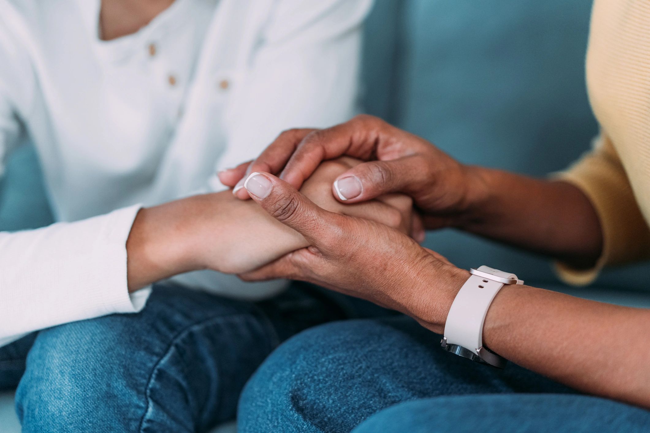 Parent holding a teenager's hand in support